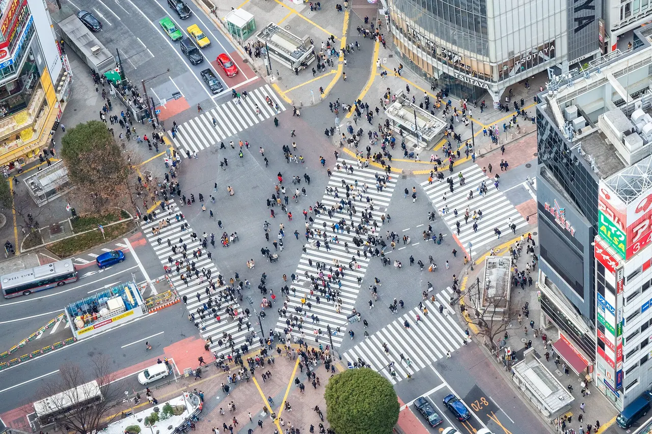 Shibuya Scramble Crossing seen from high above, with crowds crossing in every direction