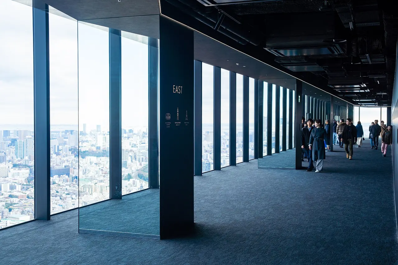 The indoor Sky Gallery corridor on the 46th floor, with floor-to-ceiling windows looking out over Tokyo