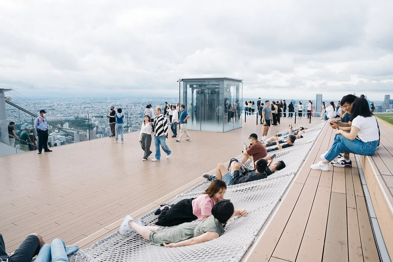 Visitors lying in the Cloud Hammock nets on the SHIBUYA SKY roof